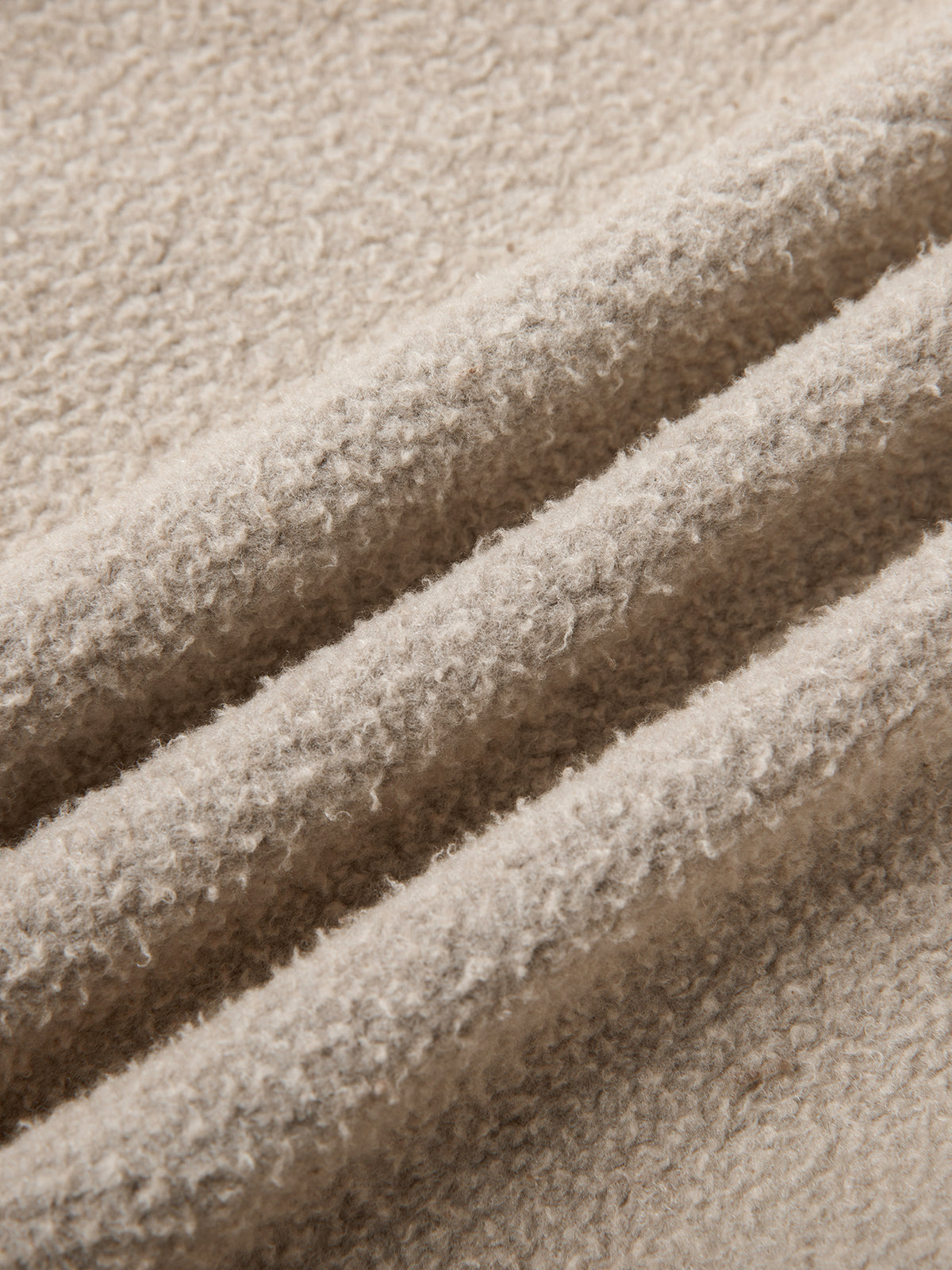 Close-up of beige textured fabric with folds