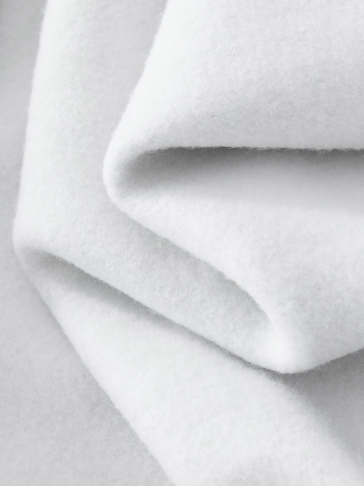 Close-up of white fabric with folds on a light gray background