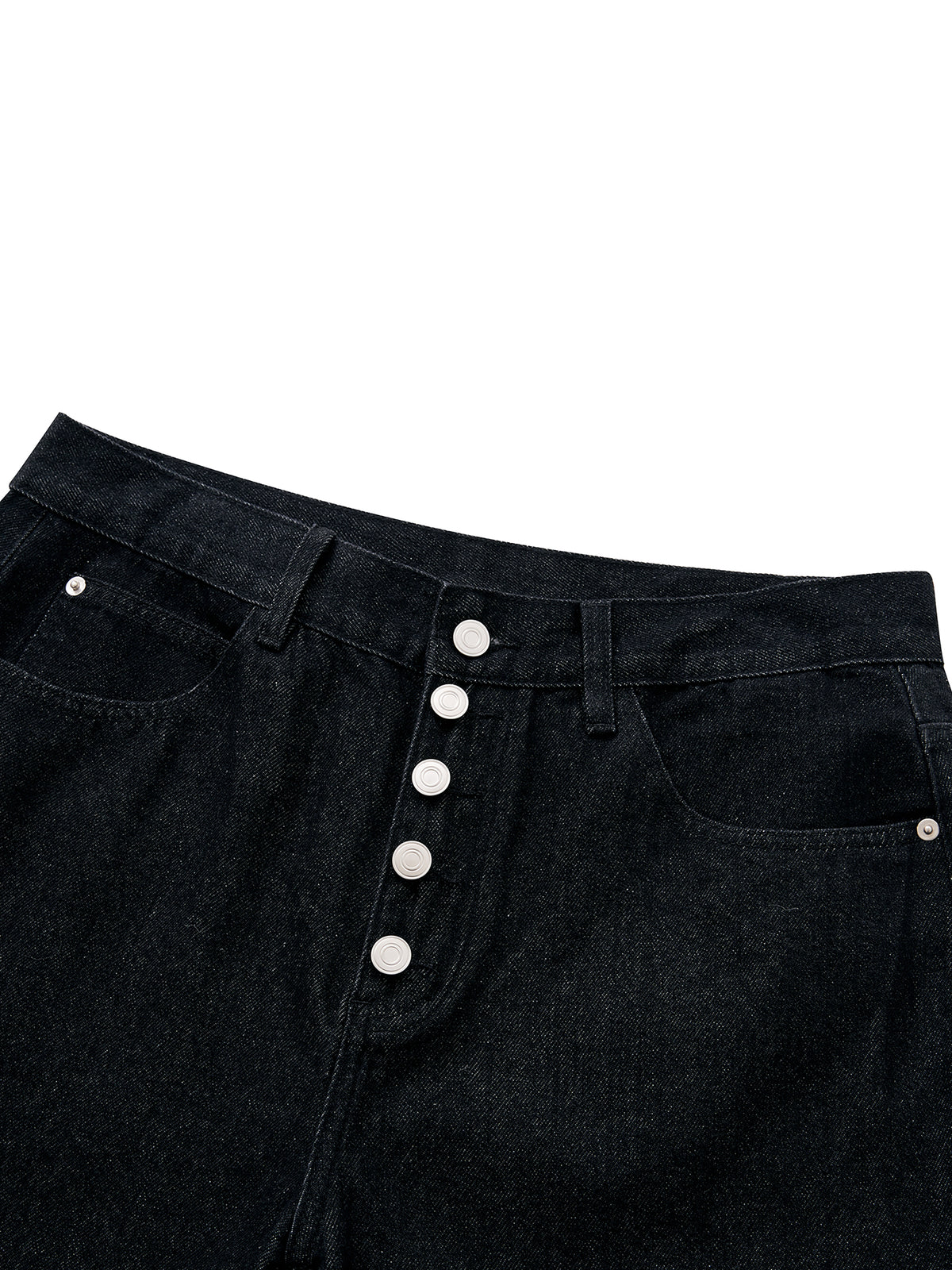 Close-up of a pair of black denim jeans showing the waistband, front pockets, and a vertical row of silver metal buttons down the center front, set against a plain white background.