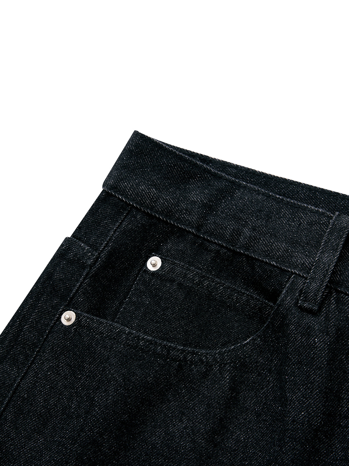 Close-up of a pair of black denim jeans showing the waistband, belt loop, and front pocket with silver rivets against a white background.