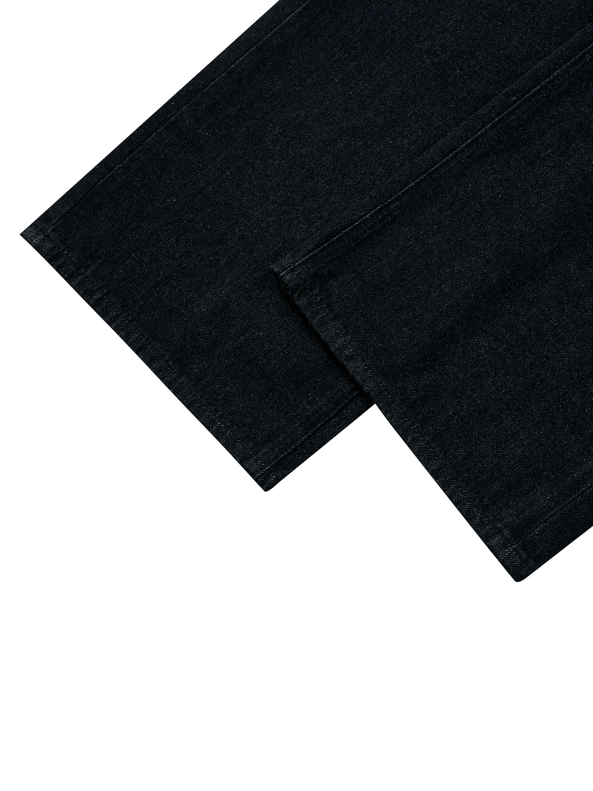 A close-up of folded black denim fabric, showing the texture and color of the material against a solid white background.