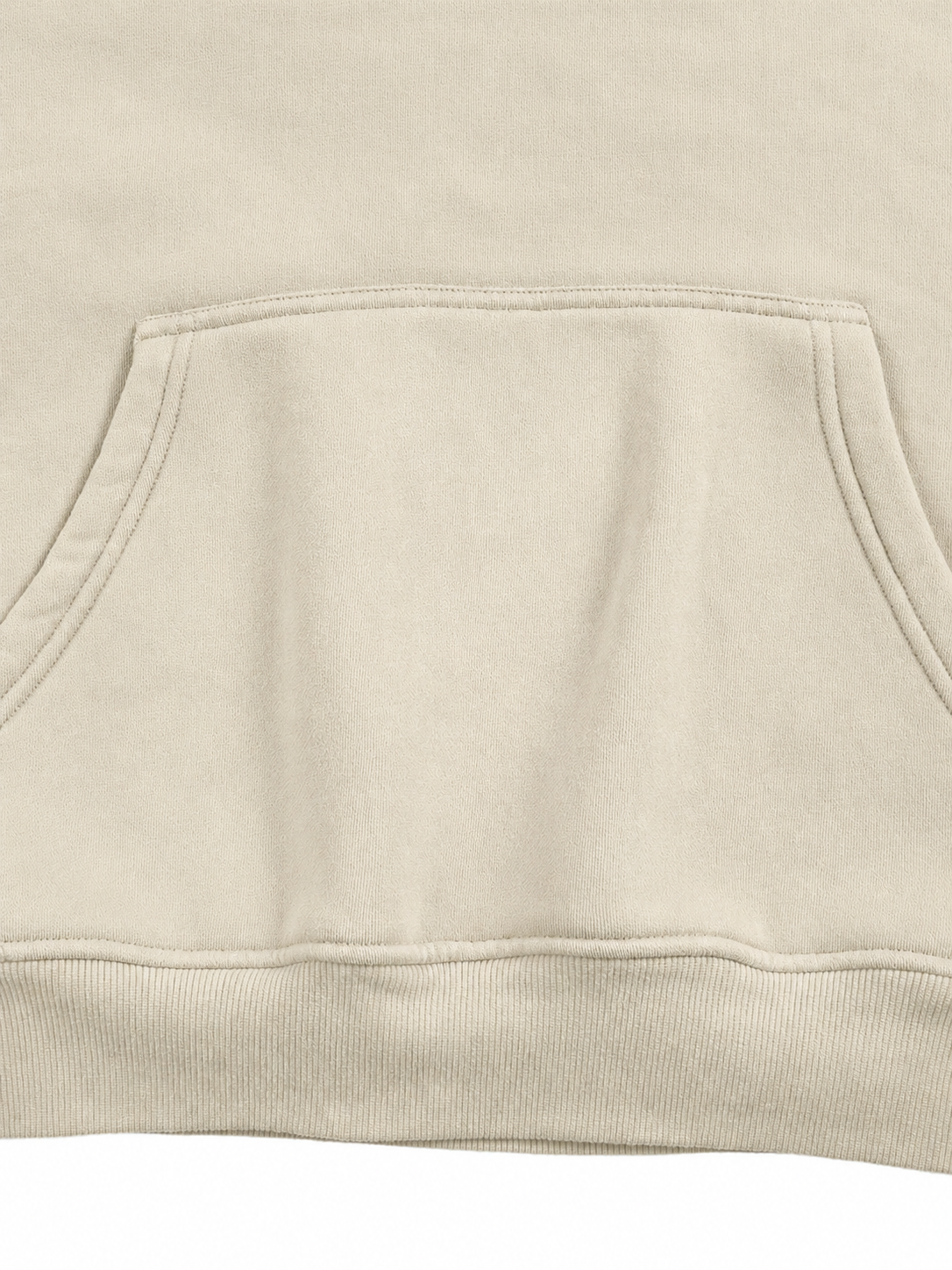 Close-up of a light beige or cream-colored sweatshirt showing the fabric texture and the edge of a front kangaroo pocket.
