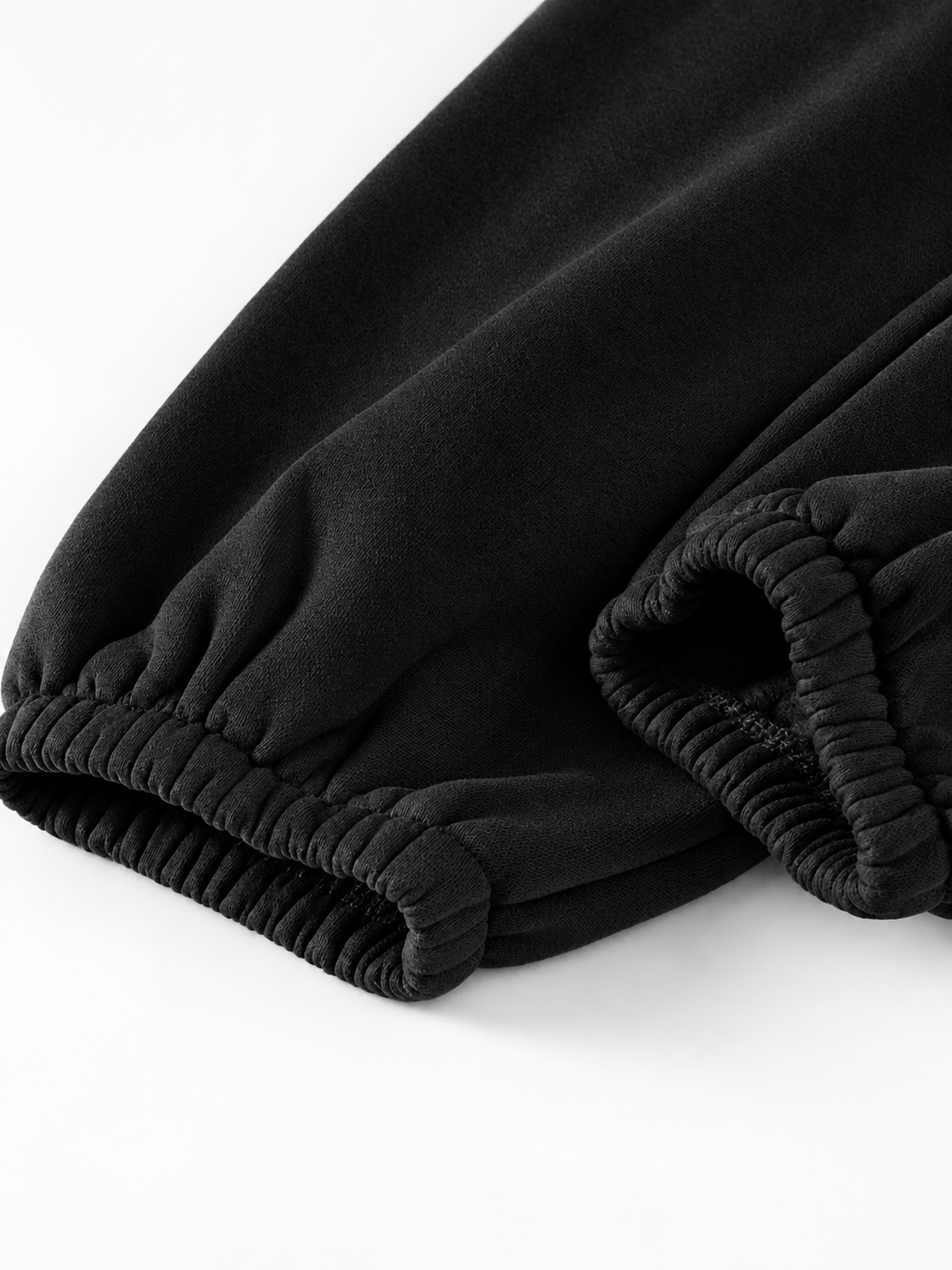 Close-up of dark olive brown ribbed elastic cuffs on a pair of pants or sweatpants, shown on a clean white background.