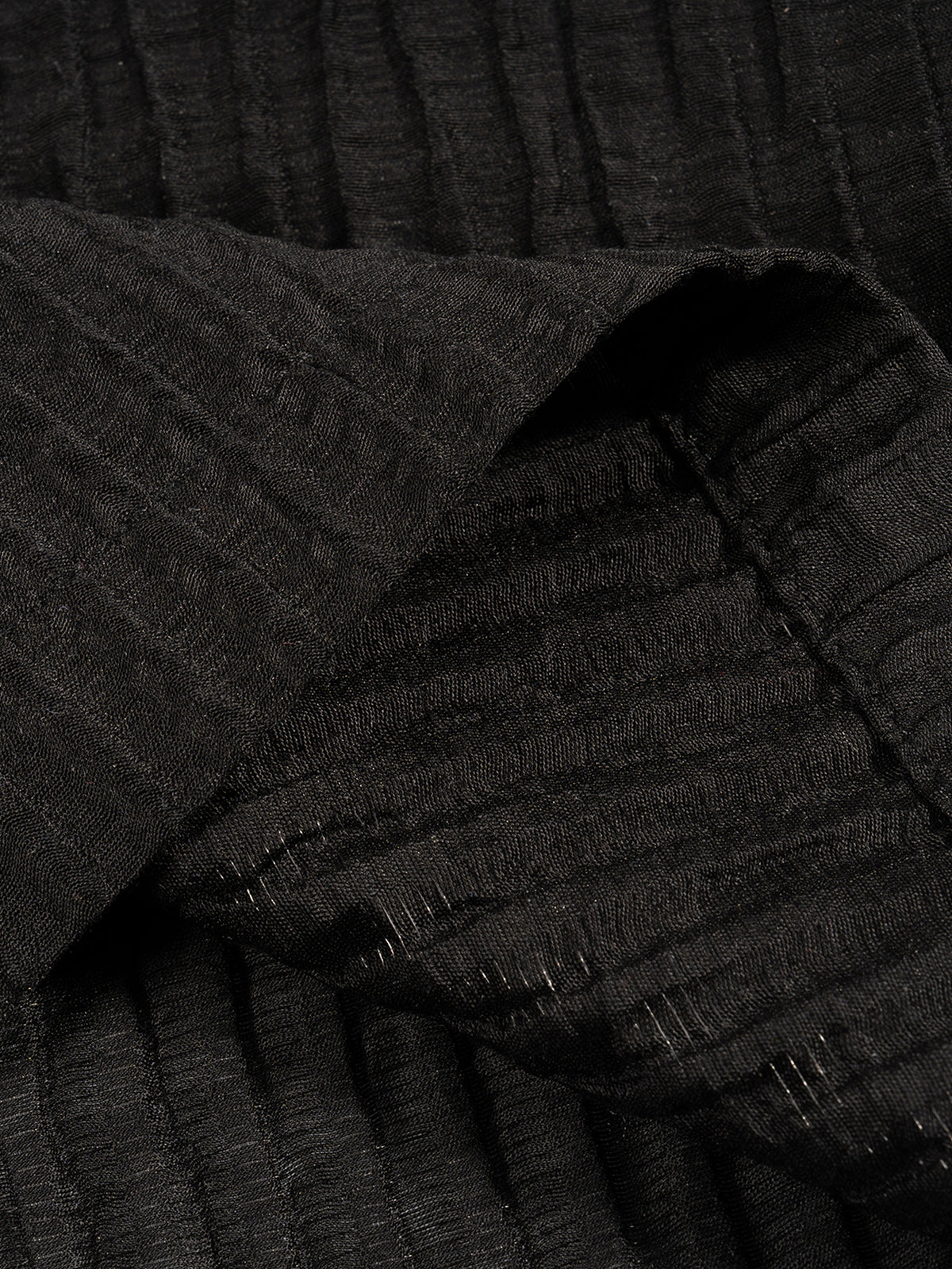 Close-up of a textured black fabric with folds