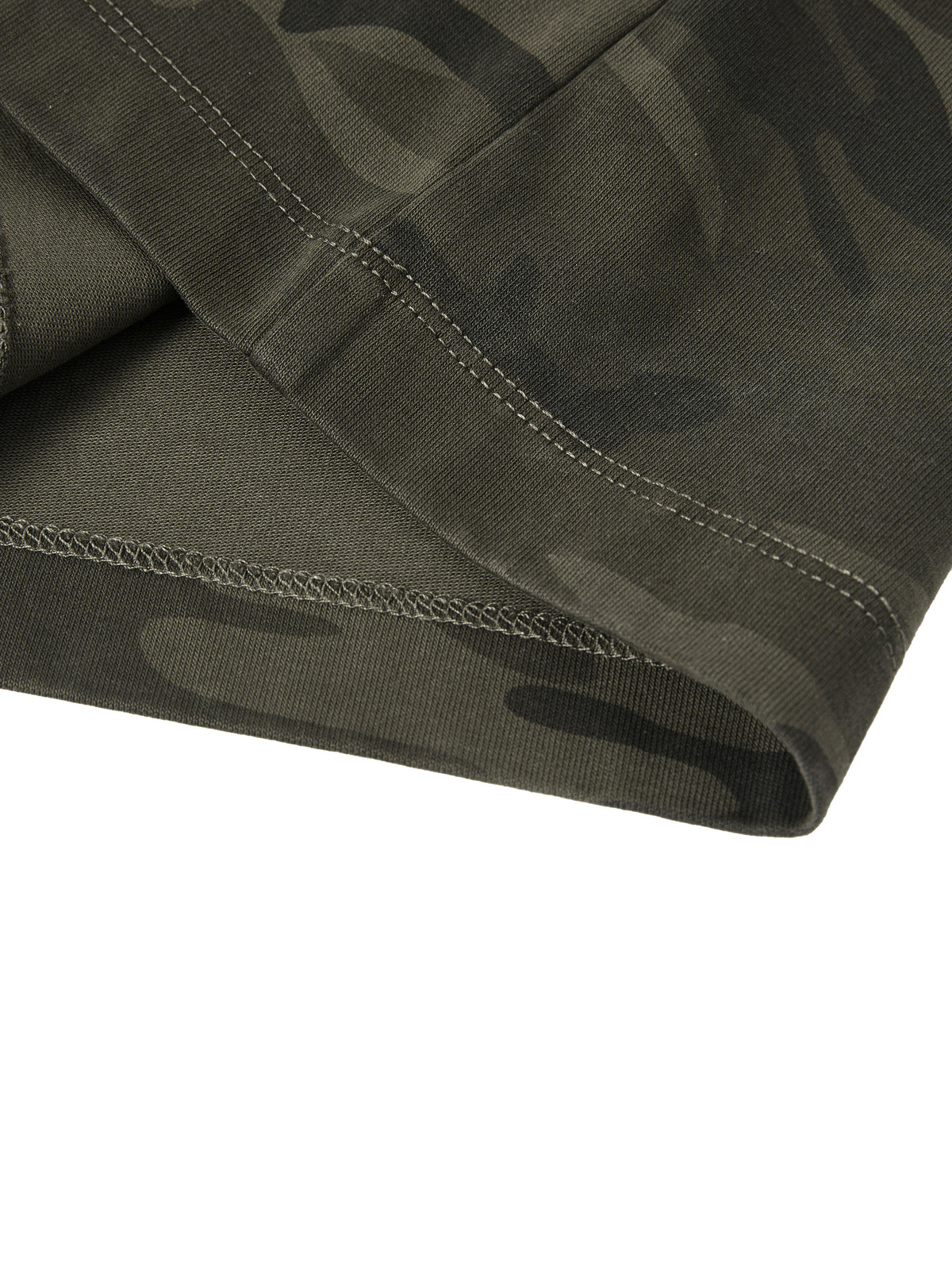 Close-up of a green camouflage fabric with stitching detail on a white background