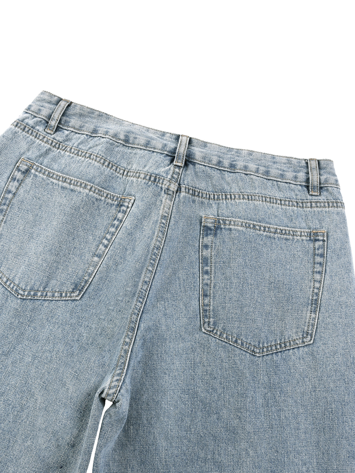 Close-up of light blue denim jeans with a white background