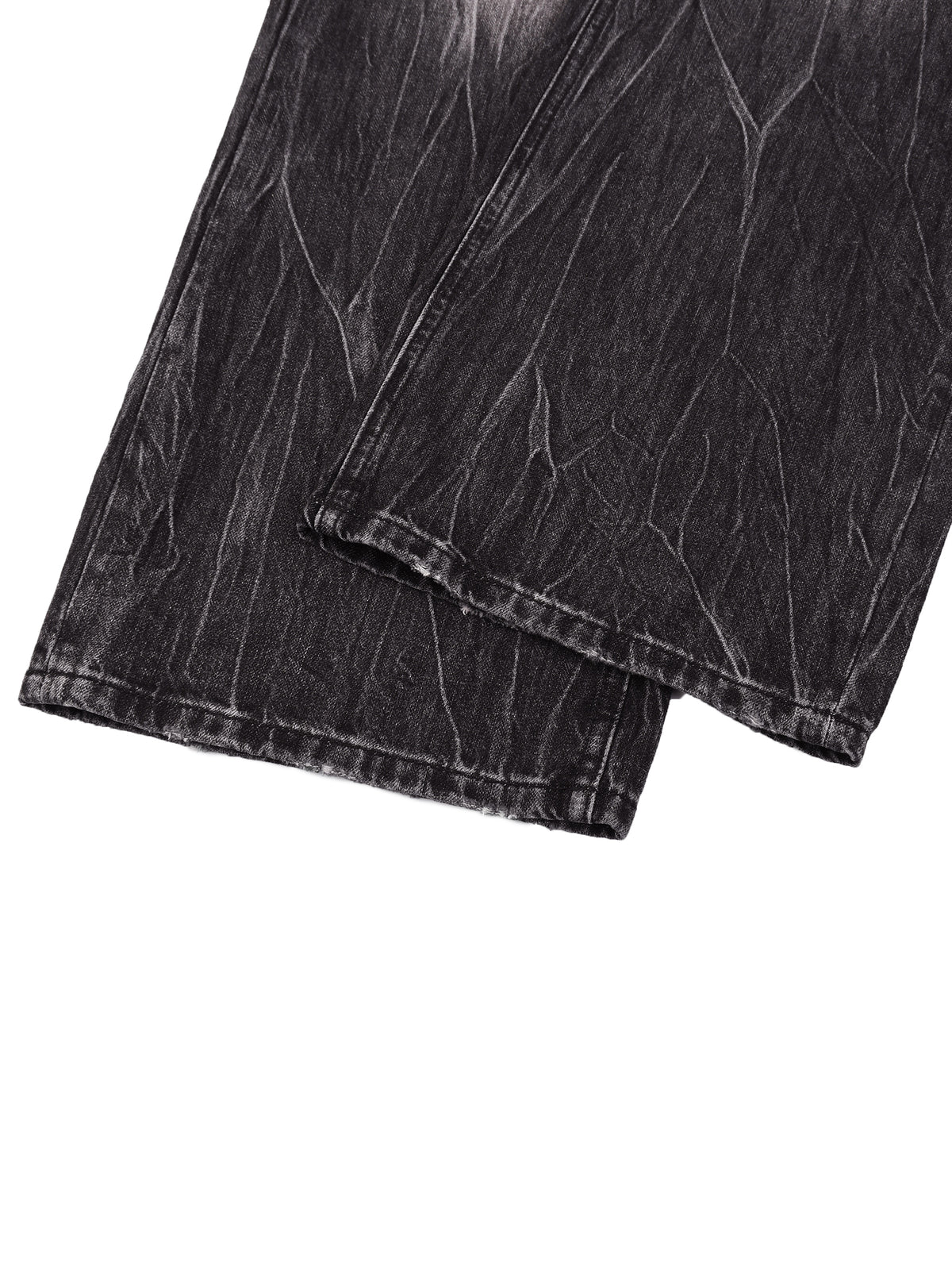 Close-up of dark gray washed denim fabric with a textured, distressed finish, folded over on a plain white background.