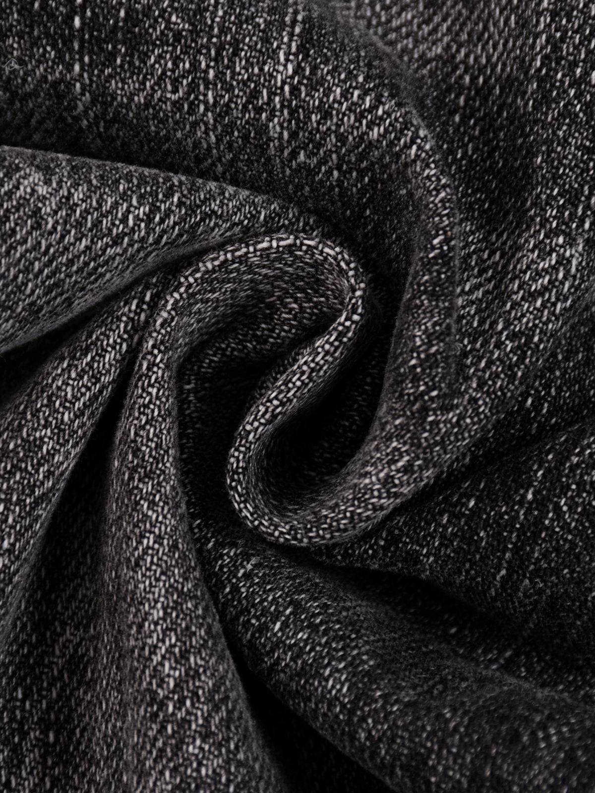 A close-up of dark charcoal gray woven fabric with a textured, heathered appearance, arranged in a spiral fold.