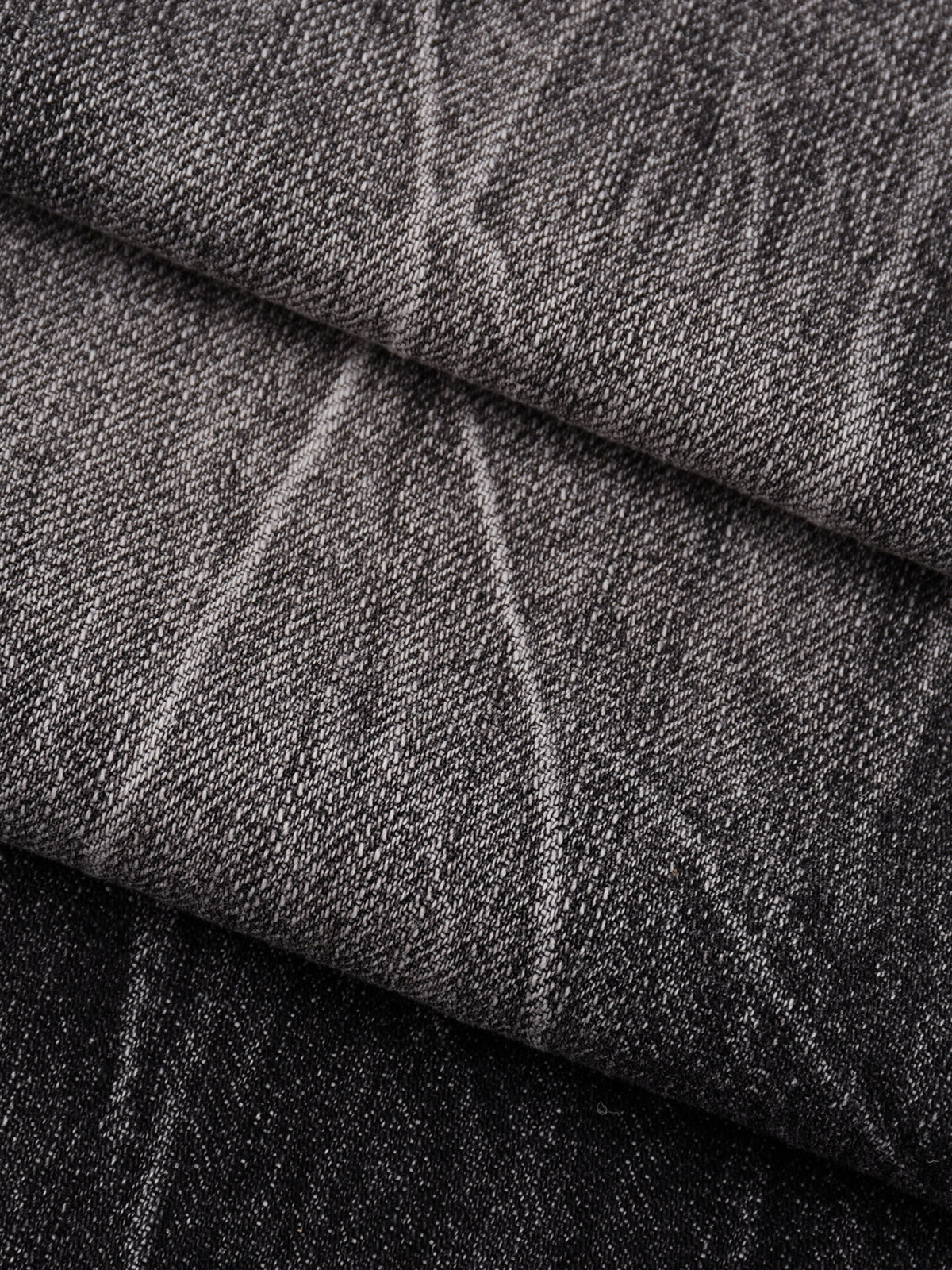 A close-up of folded dark gray woven fabric with a subtle textured pattern.