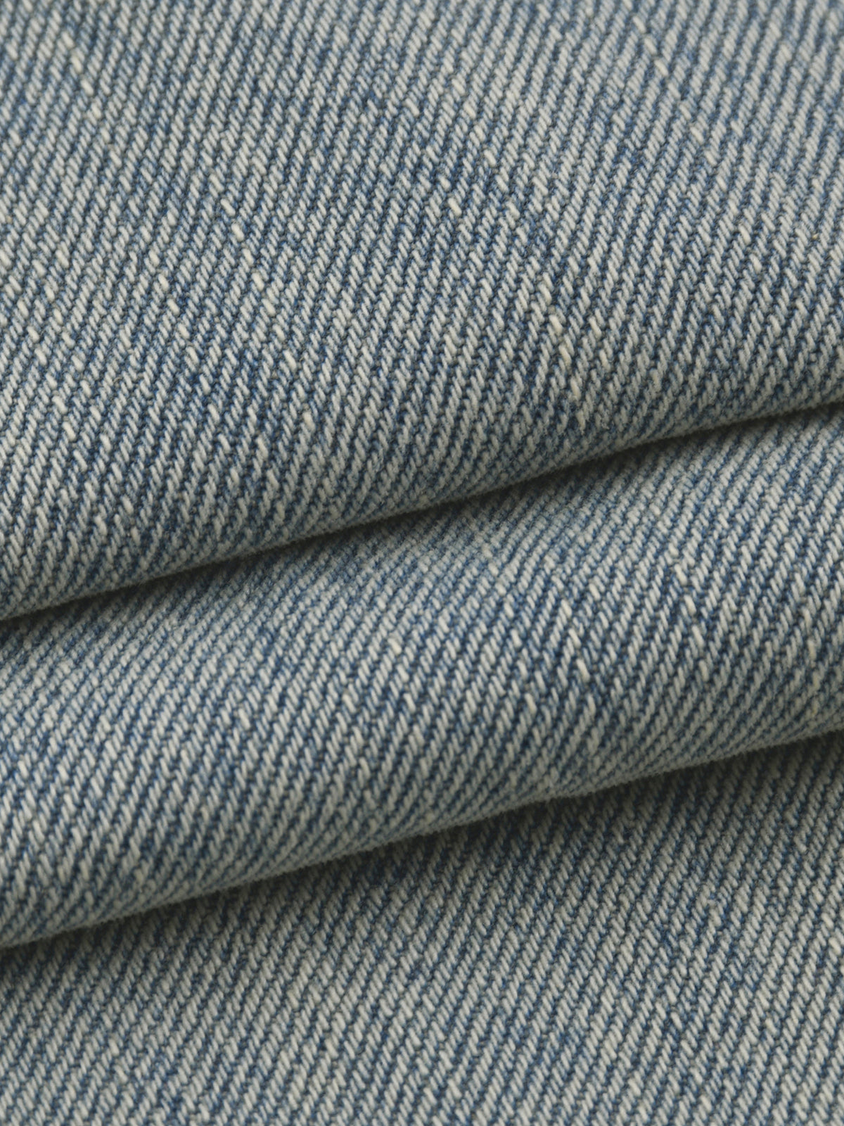 Close-up of blue denim fabric with a subtle pattern