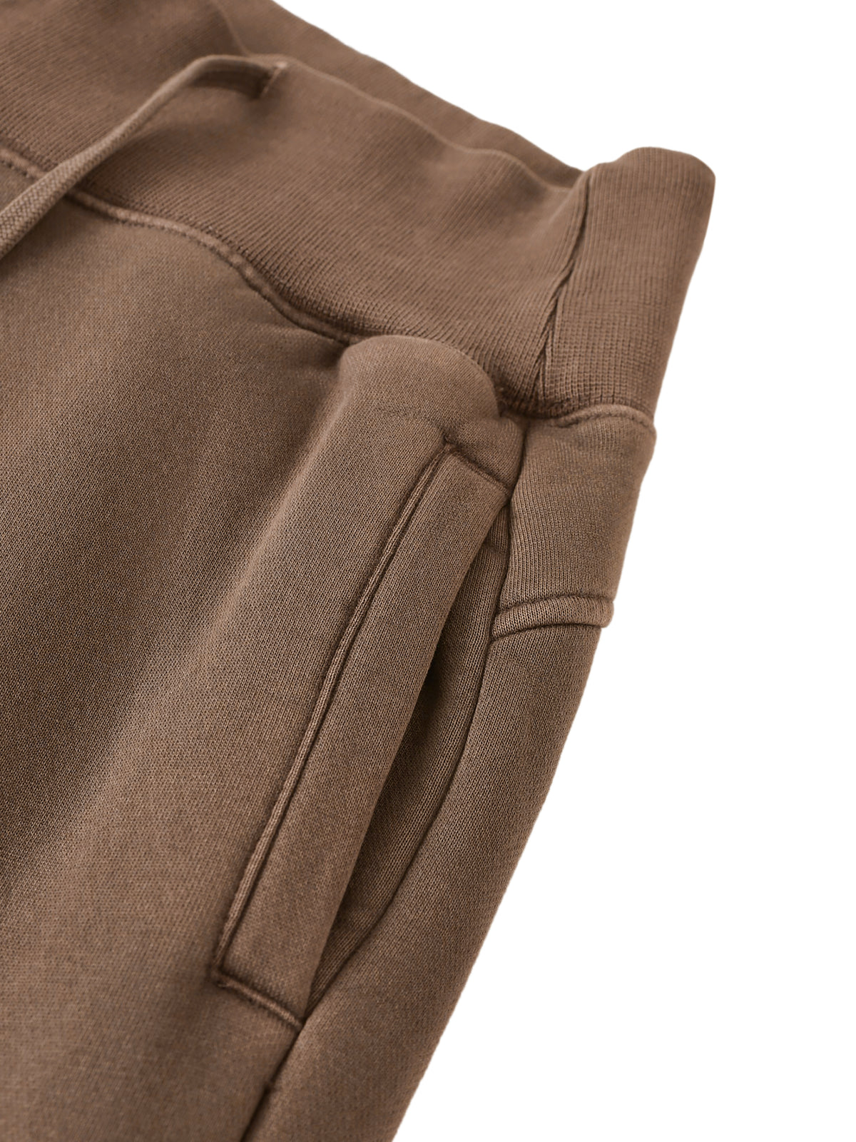 Close-up of brown sweatpants on a white background