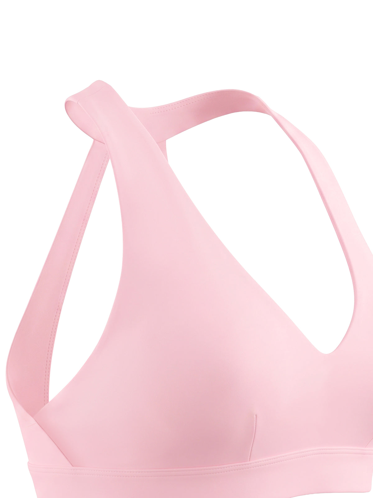 Close-up of a light pink sports bra with a crossover back strap design, shown against a plain white background.