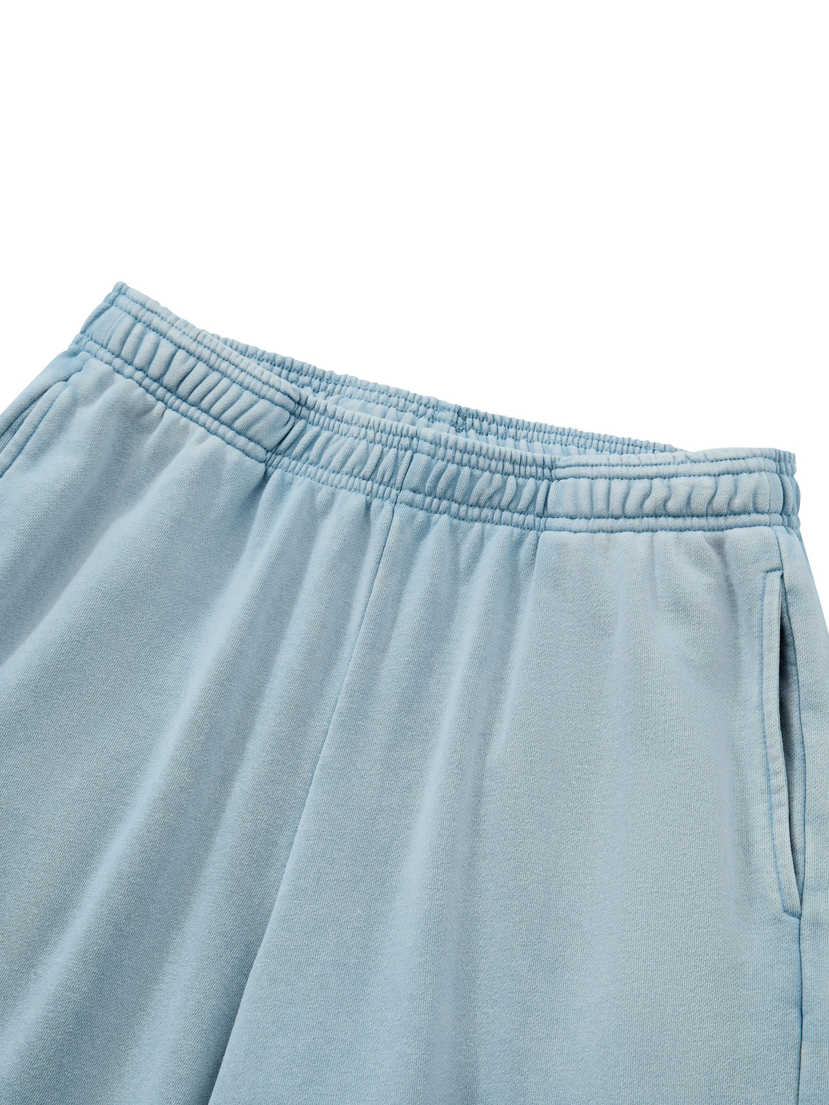 Close-up of a pair of light blue sweatpants showing the elastic waistband and side pocket detail against a white background.