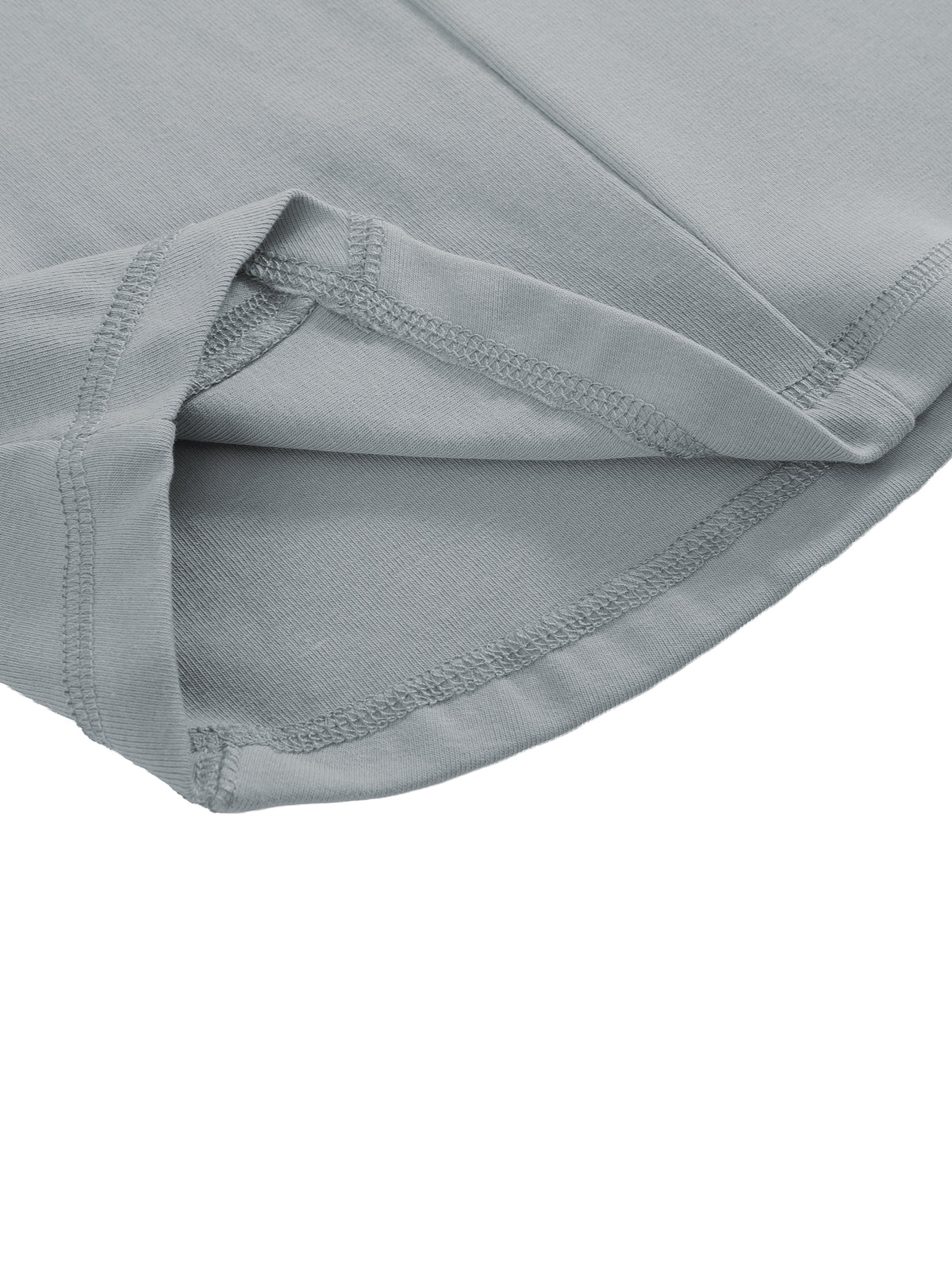 Close-up of a light gray fabric garment showing folded hem and stitched edge details on a white background.
